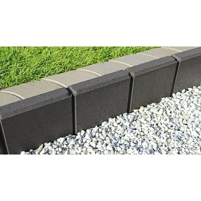 Christoph Randstein C-Line - 40 x 5 x 25 cm, Anthrazit, Beton - Nahaufnahme einer zweifarbigen Gartenrandbefestigung aus Beton zwischen Rasen und weißen Kieselsteinen.
