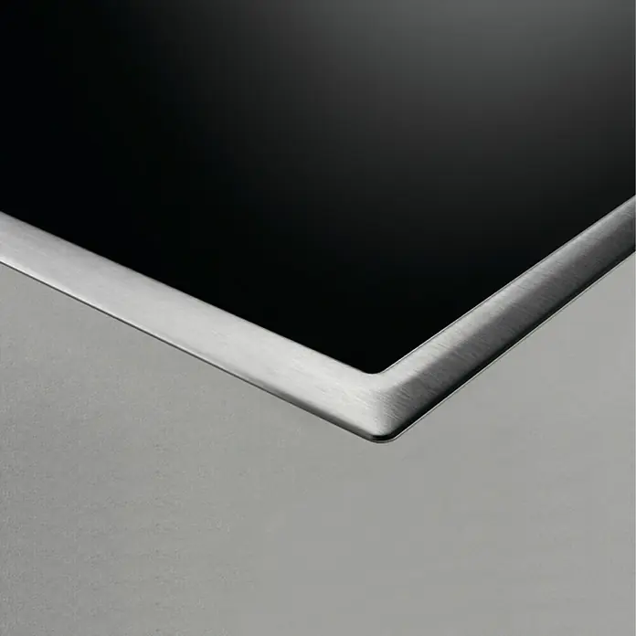 Zanussi Placa de cocción ZITN633X - Número de fogones de inducción: 3 ud. - Primer plano de un fregadero moderno de acero inoxidable con una elegante superficie negra, que combina elegancia y funcionalidad.