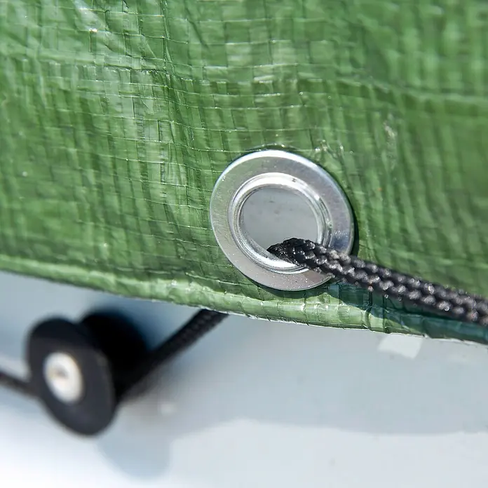 Windhager Abdeckplane Extra Heavy - 210 g/m², Kunststoff - Nahaufnahme einer grünen Plane mit einer silbernen Öse und einer schwarzen Kordel, die durch sie hindurchgezogen ist.