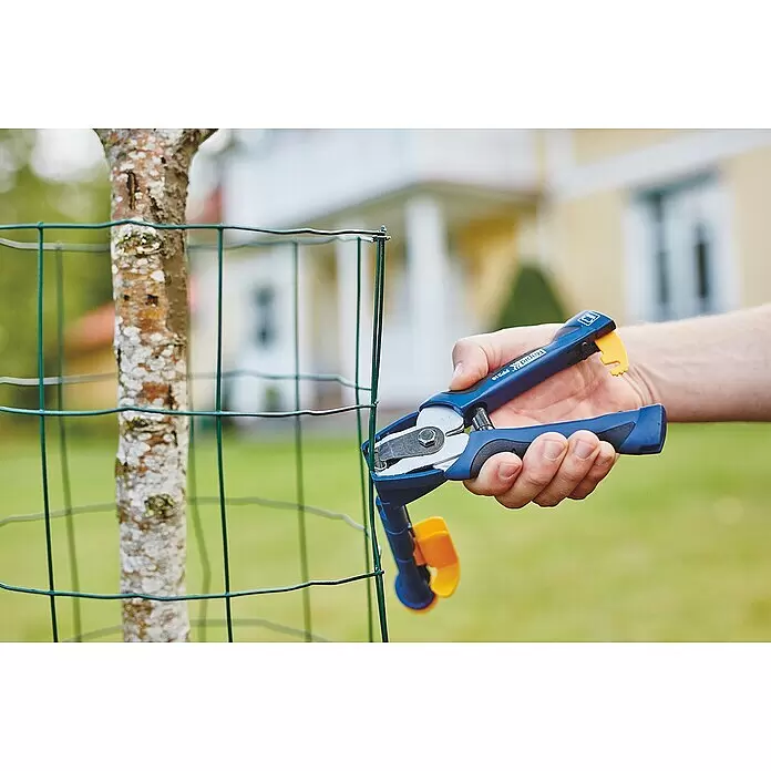 Rapid Zaunzange FP216 - Passend für: Rapid Ringklammer VR16, Ohne Ringklammern - Blaue und orange Rapid FP216 Klammerzange sichert grünen Drahtzaun um einen Baumstamm im Garten.