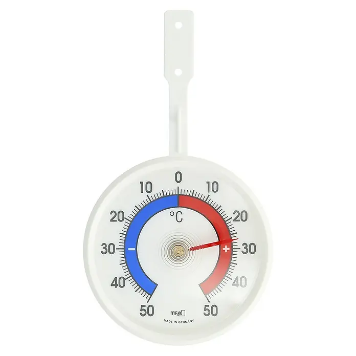TFA Dostmann Fensterthermometer - Analog - Ein weißes TFA-Thermometer zur Wandmontage, das die Temperatur in Grad Celsius anzeigt. Die Temperatur liegt bei etwa 28 Grad.
