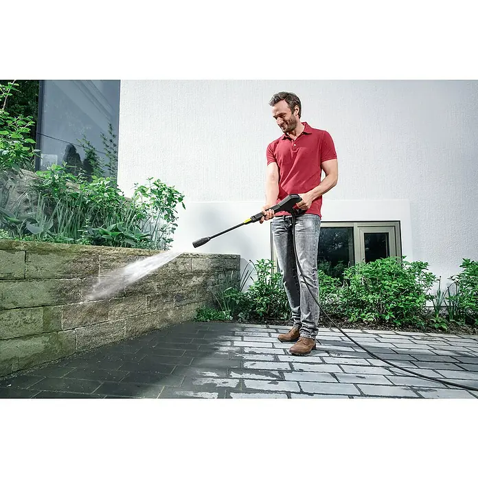 Kärcher Hochdruckreiniger K 3 Power Control - 120 bar, 1.600 W, Fördermenge: 380 l/h - Ein Mann benutzt einen Kärcher Hochdruckreiniger, um eine Steinmauer zu säubern, wobei der Fokus auf dem Kärcher liegt.