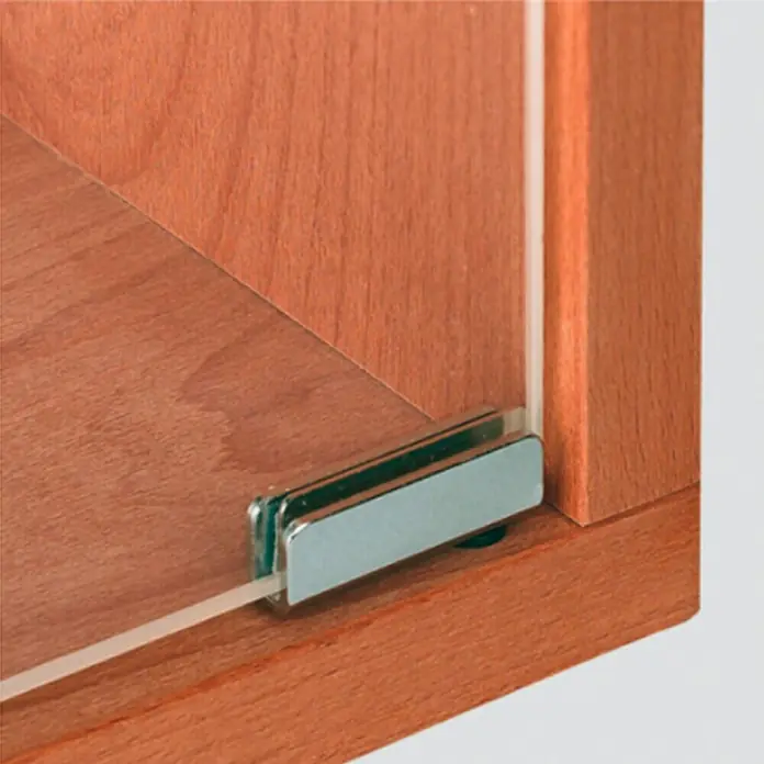 Häfele Bisagra para puertas de cristal - 40 x 13,5 mm, Ángulo de apertura: 110 °, Cromo - Primer plano de un carril guía de puerta corredera de vidrio fijado a un armario de madera. Herraje de alta calidad para muebles.
