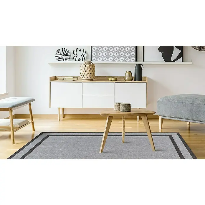 Alfombra de vinilo Marco - Plata, 230 x 160 cm - Interior con alfombra gris con borde estrecho y oscuro debajo de una mesa de madera, con muebles a juego al fondo.