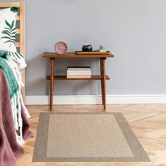 Alfombra de vinilo Living - Beige/Tostado, 200 x 60 cm - Una alfombra beige con un borde marrón chocolate está sobre un suelo de parquet en un dormitorio.