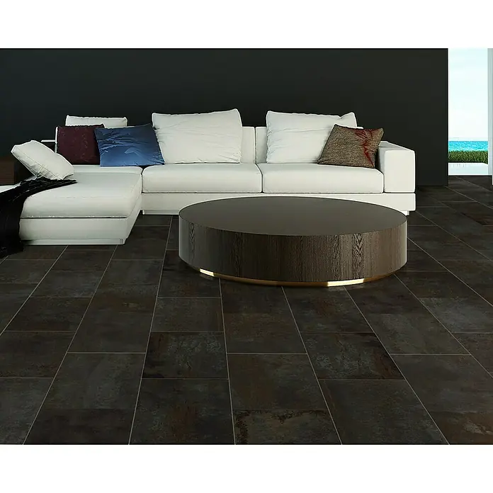 Feinsteinzeugfliese Flatiron - 60 x 120 cm, Schwarz, Matt - Modernes Wohnzimmer mit dunklen Fliesen, einem weißen Sofa und einem runden Couchtisch, der eine elegante Atmosphäre schafft.