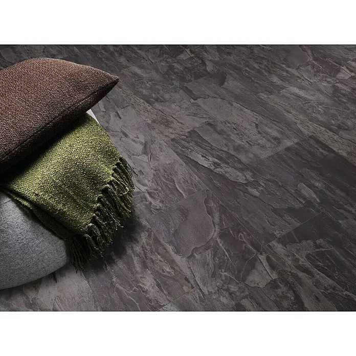 LOGOCLIC Hartvinylboden ElementPro Deep Blue - 1.210 x 295 x 5 mm, Fliese, Deep Blue - Nahaufnahme von Bodenbelägen in Steinoptik mit Kissen und Decke, die die Textur und das Design des Bodenbelags hervorheben.