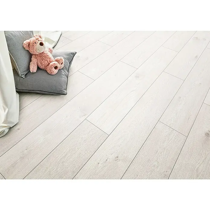 LOGOCLIC Hartvinylboden ElementPro Creamy Oak - 1.210 x 234 x 5 mm, Landhausdiele, Creamy Oak - Helle Holzdielen mit einem Teddybär auf einem Kissen. Das helle Laminat erzeugt eine freundliche und einladende Atmosphäre.