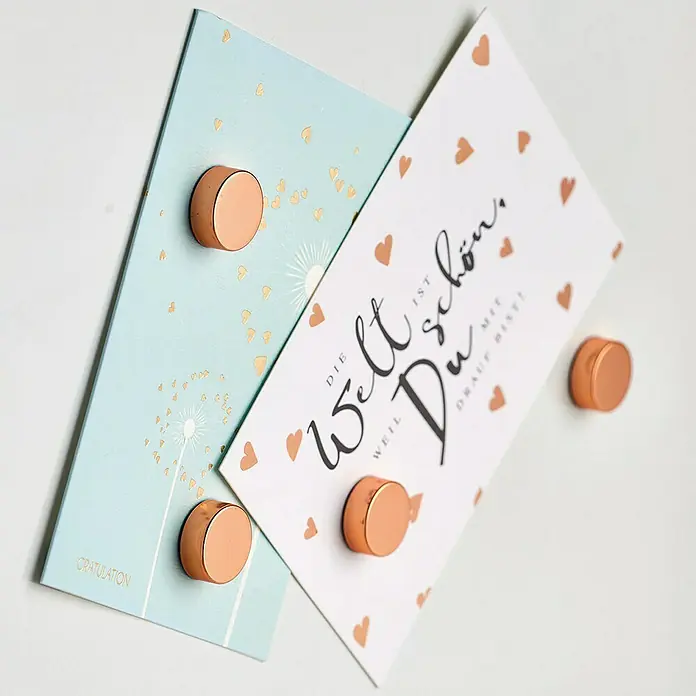 Zeller Present Magnet-Set Extrastark - Rosegold, Gesamtstückzahl: 4 - Zwei Karten mit Kupfermagneten, die an einer Wand befestigt sind, eine davon mit der Aufschrift "Die Welt ist schön".