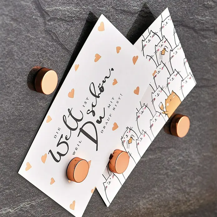 Zeller Present Magnet-Set Extrastark - Rosegold, Gesamtstückzahl: 4 - Grußkarte mit Katzenmotiv und Herzen, befestigt mit runden, kupferfarbenen Magneten auf einer grauen Oberfläche.
