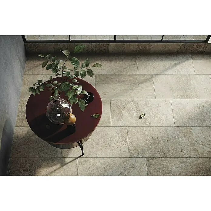 Atlas Concorde Solution Regent Feinsteinzeugfliese Ivory - 30 x 60 cm, Beige/Braun, Matt - Draufsicht auf einen Raum mit Fliesenboden, einem runden Tisch mit Pflanze, Vase und Dekoration, der dem Raum eine natürliche Note verleiht.