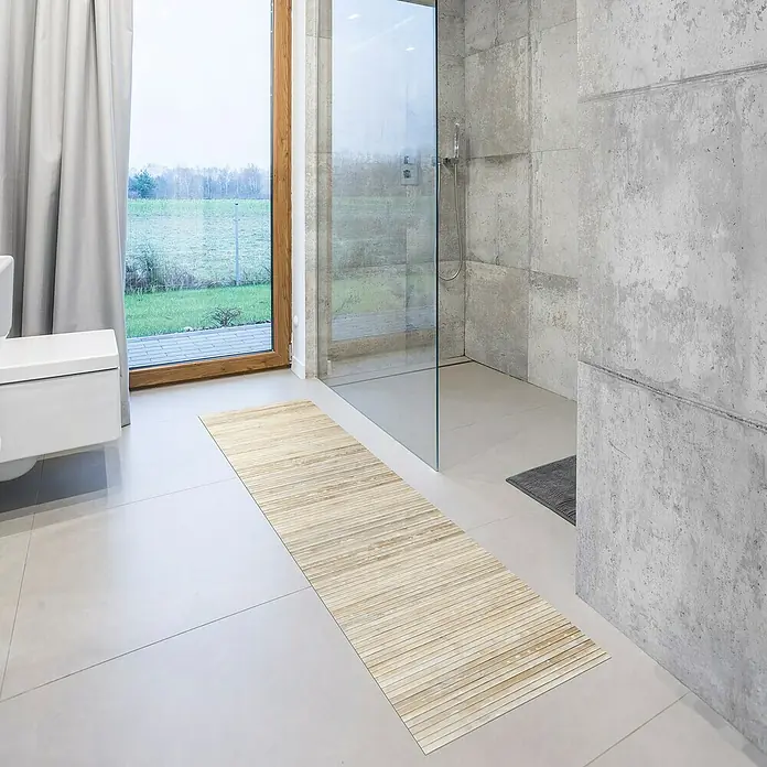 Alfombra de bambú Cool - Yeso, 200 x 50 cm - Una alfombra de baño de bambú marrón claro está colocada en un suelo de baldosas claras en un baño.