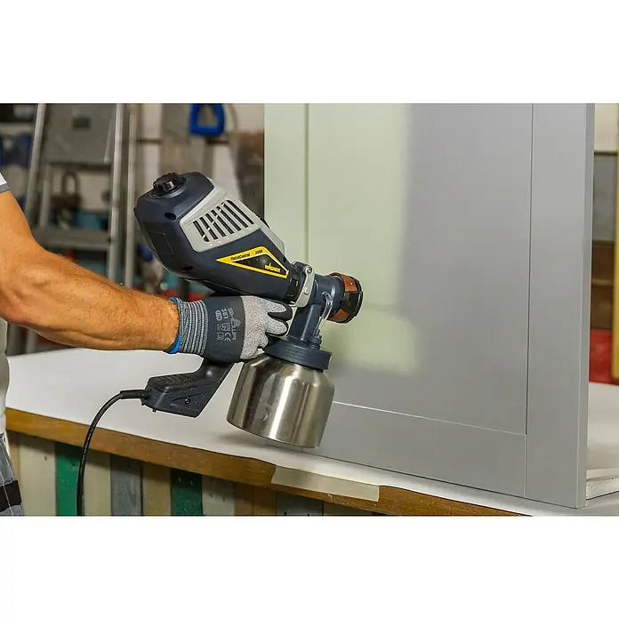 Wagner XVLP Farbsprühsystem FinishControl 3500 - 700 W - Nahaufnahme einer Person, die mit einer Wagner FinishControl 3500 Farbspritzpistole ein graues Paneel lackiert, was die präzise Anwendung und das Finish betont.
