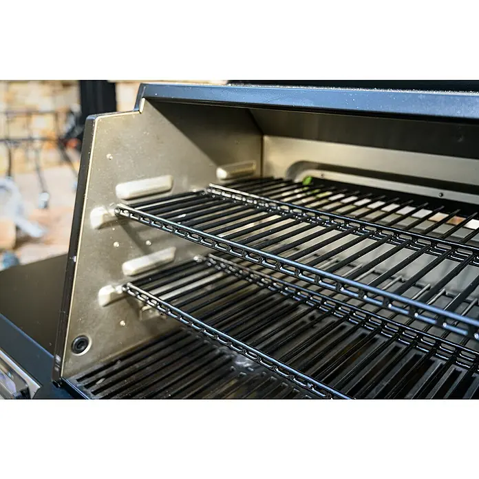 Masterbuilt Warmhalterost - L x B: 13,7 x 56,5 cm, Passend für: Masterbuilt Holzkohlegrill & Smoker Gravity 560 - Nahaufnahme des Innenraums eines Grills mit mehreren Rosten, ideal zum gleichzeitigen Garen verschiedener Speisen.