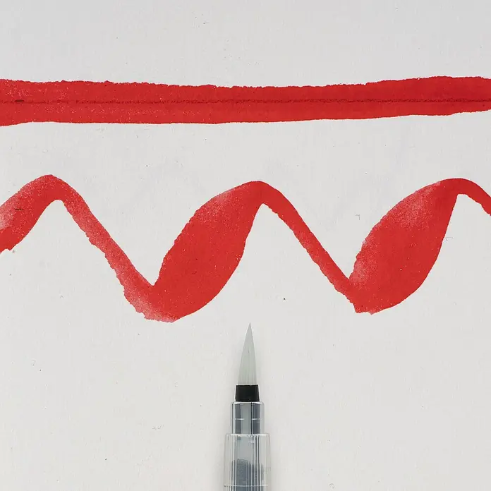 Talens Sakura Pincel artístico Koi - Tamaño pincel: Largo, Fibra sintética, Plástico - Primer plano de un pincel de agua junto a trazos de pintura roja sobre papel blanco, destacando la herramienta versátil.