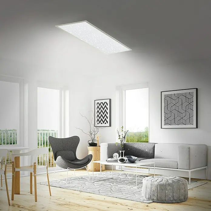 Briloner LED-Panel Sternenhimmel - 36 W, L x B x H: 119,5 x 29,5 x 6,5 cm, Weiß, Warmweiß - Ein modernes Wohnzimmer mit einer rechteckigen LED-Deckenleuchte, die ein sternenähnliches Muster aufweist und eine helle Atmosphäre schafft.