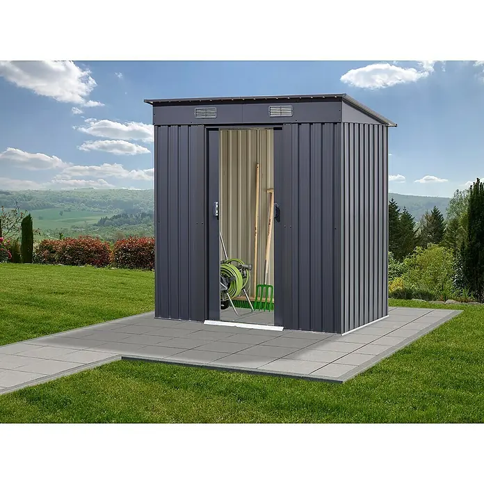 Floraworld Gerätehaus - Außenmaß inkl. Dachüberstand (B x T): 195 x 121 cm, Stahl - Ein grauer Metall-Gartenschuppen mit Schiebetüren steht auf einer gepflasterten Fläche im Grünen. Gartenwerkzeuge sind im Schuppen.