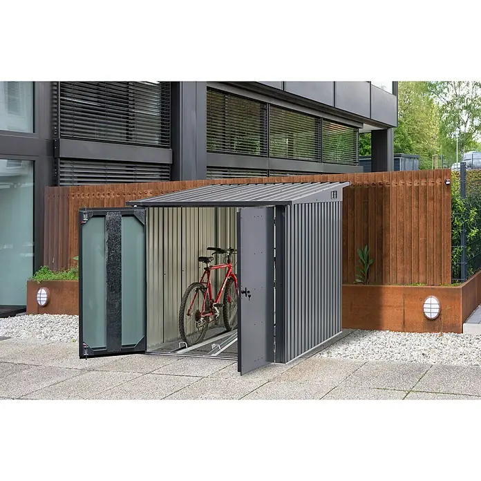 Floraworld Fahrradgarage - 204 x 163 x 163 cm, Stahl, Passend für: 3 Fahrräder bis 26″ - Eine Fahrradgarage aus Metall mit einem geöffneten, rechteckigen Eingang und einem roten Fahrrad darin, vor einem Gebäude.