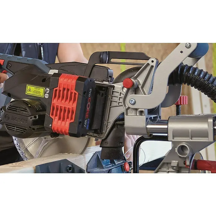 Bosch Professional AMPShare 18V Akku-Kapp- & Gehrungssäge 18V-216 Solo - 18 V, Ohne Akku, Durchmesser Sägeblatt: 216 mm - Eine Bosch Akku-Kapp- und Gehrungssäge mit einem Pro Core 18V Akku beim Sägen eines Holzstücks.