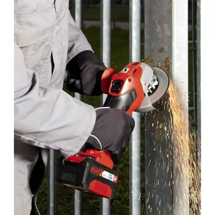 Einhell PXC 18V Amoladora angular de batería Axxio 18/115 Q - 18 V, Sin batería, Diámetro disco: 115 mm, 8.500 r.p.m. - Una persona usa una amoladora angular inalámbrica Einhell roja y negra para amolar un poste de metal, con chispas que salen de la herramienta.