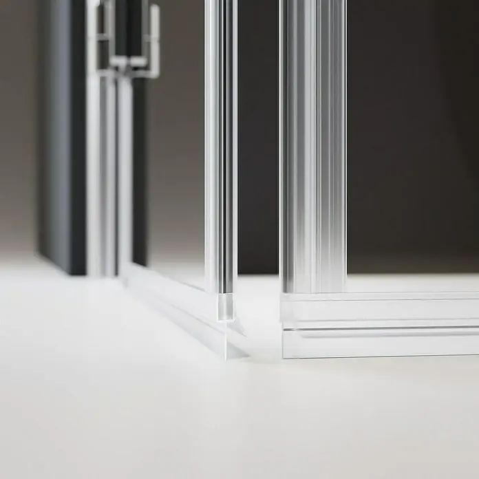 Camargue Air Wasserabweisprofil - Kunststoff, Transparent - Detailaufnahme einer Duschkabine mit klaren Glaspaneelen und silbernen Aluminiumprofilen auf einer weißen Oberfläche.
