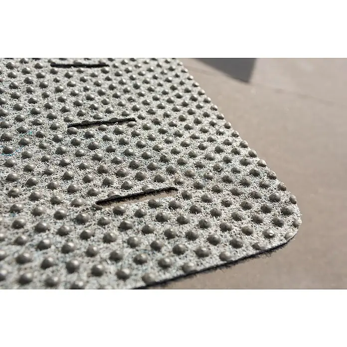 Astra Fußmatte Perfo Rips - Beige, 40 x 60 cm, 100 % Polypropylen - Nahaufnahme einer strukturierten, grauen Badematte mit Noppen und Schlitzen für sicheren Halt und Komfort im Badezimmer.