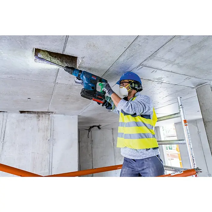 Bosch Professional AMPShare 18V Akku-Kombihammer GBH 18V-36 C - 18 V, Ohne Akku, 7 J - Ein Bauarbeiter bohrt mit einem Bosch Bohrhammer ein Loch in eine Betondecke, um Kabel zu verlegen.