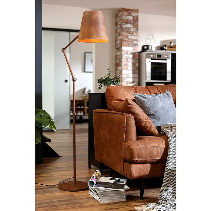 Celina Klinker Verblendstein-Ecke Vintage New York - 24,5 cm x 7,1 cm x 15 mm, Braun/Rot, Steinoptik - Eine Stehlampe aus Metall mit einem verstellbaren Arm und einem Lampenschirm, der ein warmes Licht ausstrahlt, neben einem braunen Sofa.