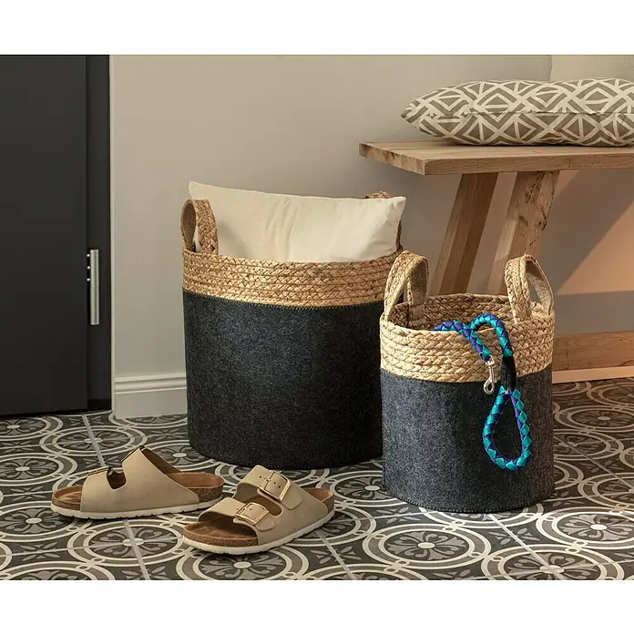 Feinsteinzeugfliese Vintage Classic25 x 25 cm, Schwarz/Grau/Weiß, Matt - Körbe aus Seegras und Filz stehen auf einem gemusterten Boden, neben einem Paar Sandalen und einem Holzbeistelltisch.