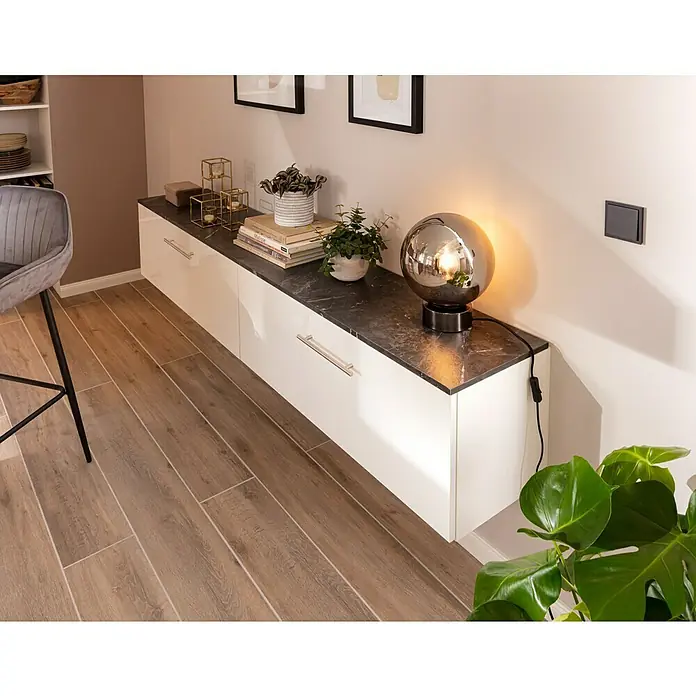 SCHÖNER WOHNEN-Farbe Wandfarbe Designfarbe - Ästhetisches Betongrau, Matt, 2,5 l, Konservierungsmittelfrei - Diese Aufnahme zeigt ein elegantes weißes Sideboard mit dunkler Marmorplatte, das mit Deko-Elementen und einer modernen Lampe geschmückt ist.