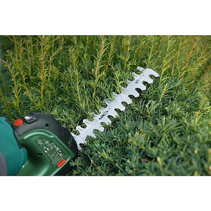 Bosch Power for All 18V Podadora de batería AdvancedShear 18 - 18 V, Iones de litio, Sin batería, Anchura de la hoja: 10 cm - Primer plano de un cortasetos inalámbrico Bosch cortando un seto verde, mostrando la cuchilla afilada.