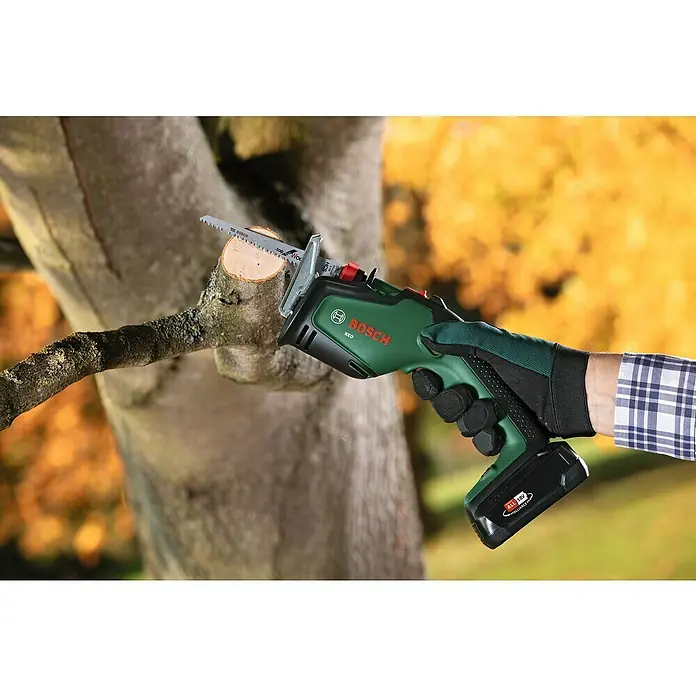 Bosch Power for All 18V Gartensäge Keo - 18 V, Li-Ionen, Ohne Akku - Die Bosch Keo Akku-Gartensäge schneidet einen Ast im Garten. Das Gerät ist grün und schwarz, mit einem Sägeblatt aus Metall.