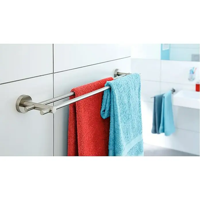 Tesa Toallero de baño MO212 - Ancho: 115 mm, Doble, Efecto de acero inoxidable - Un toallero doble de acero inoxidable con una toalla roja y una azul en un baño, montado en una pared blanca.
