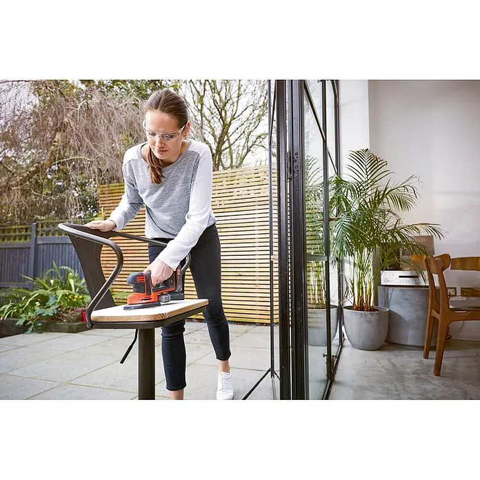 Black+Decker 18V PowerConnect Lijadora delta de batería BDCDS18N-XJ - 18 V, Iones de litio, Sin batería - Mujer lijando una silla con una lijadora Black+Decker. ¡La máquina ideal para lijar muebles!