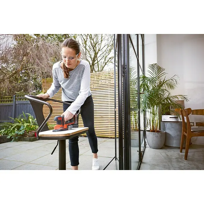 Black+Decker 18V PowerConnect Lijadora delta de batería BDCDS18N-XJ - 18 V, Iones de litio, Sin batería, 24.000 r.p.m. - Mujer lijando una silla con una lijadora Black+Decker. ¡La máquina ideal para lijar muebles!