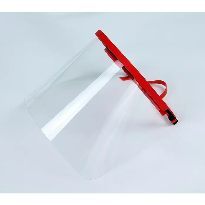 Tayg Pantalla protectora infantil - Plástico, Reutilizable - Primer plano de un protector facial con diadema roja y visera transparente sobre un fondo de color claro.