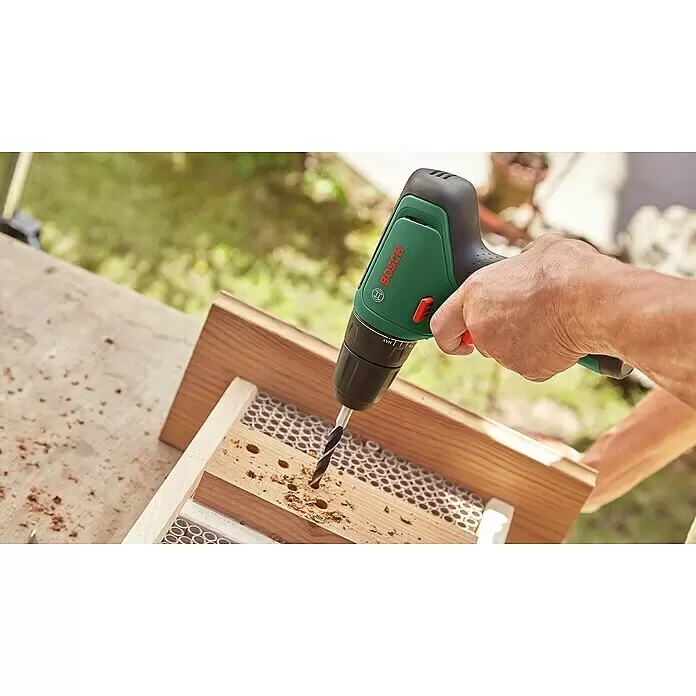 Bosch Power for All 12V Akku-Bohrschrauber EasyDrill 1200 - 12 V, 2 Akkus, 1,5 Ah - Eine Person bohrt mit einem grün-schwarzen Bosch-Bohrer Löcher in ein Holzinsektenhotel.