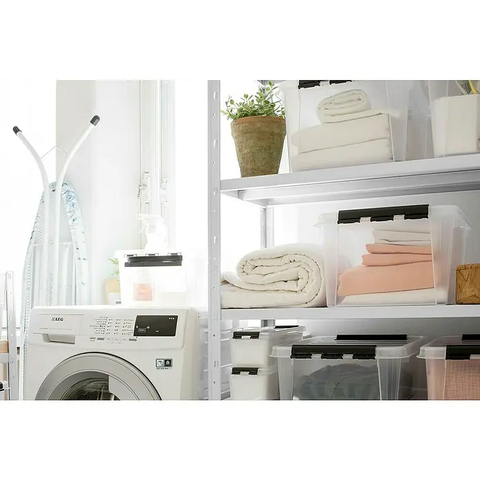 SmartStore Aufbewahrungsbox Classic 31 - L x B x H: 50 x 39 x 26 cm, Kunststoff, Transparent - Ein Waschraum mit einer AEG-Waschmaschine und weißen Regalen, die mit transparenten Aufbewahrungsboxen mit Wäsche gefüllt sind.