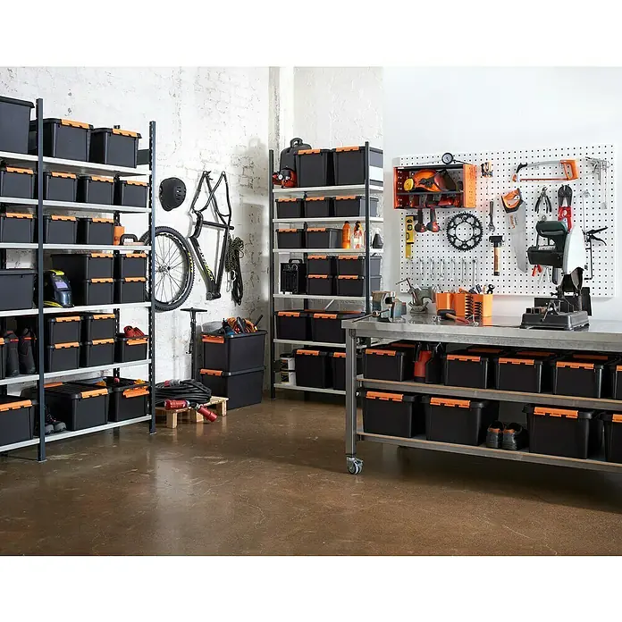 SmartStore Aufbewahrungsbox Pro 49 - L x B x H: 59 x 39 x 34 cm, Kunststoff, Schwarz - Eine Werkstatt mit Regalen voller schwarzer Lagerboxen mit orangefarbenen Akzenten, Werkzeugwand und Werkbank.