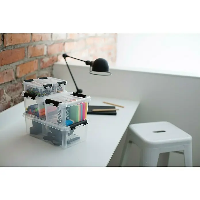 SmartStore Aufbewahrungsbox Classic 1,5 - L x B x H: 20 x 15 x 11 cm, Kunststoff, Transparent - Stapel von transparenten Aufbewahrungsboxen mit schwarzen Verschlüssen auf einem weißen Tisch, ideal zur Organisation von Büromaterialien.
