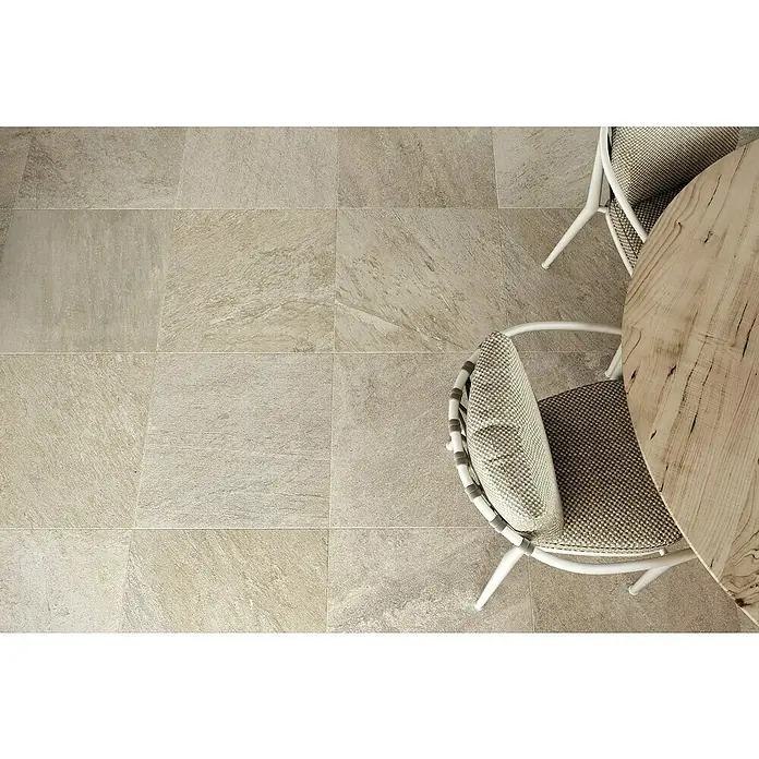Atlas Concorde Solution Regent Terrassenfliese Ivory - 60 x 60 x 2 cm, Beige/Braun, Matt - Hochwinkelaufnahme eines Tisches und Stühle auf einem Boden aus grauen Feinsteinzeugfliesen.