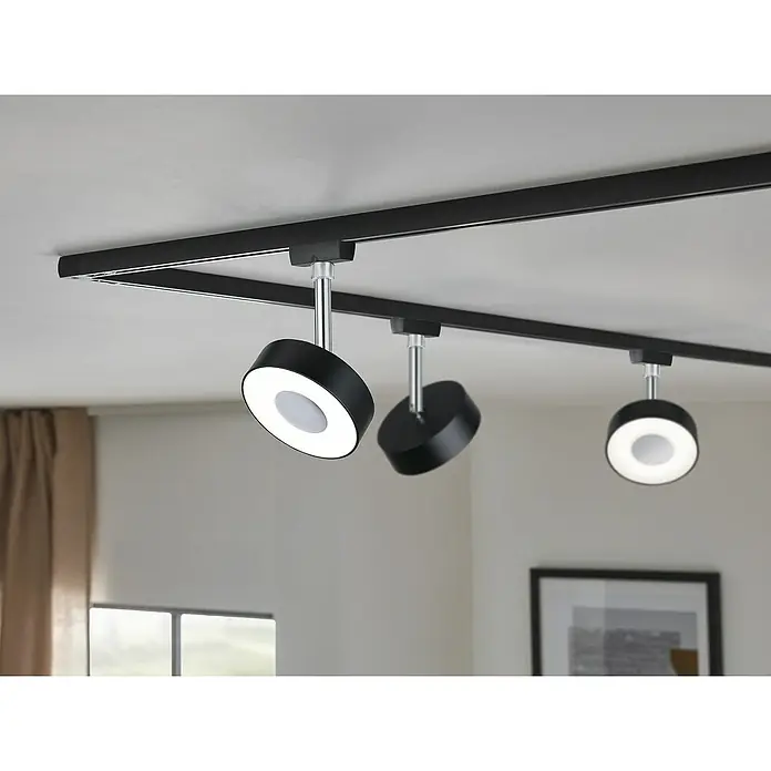 Paulmann URail LED-Spot Circle - 5 W, Schwarz, Chrom, Neutralweiß - Diese Aufnahme zeigt ein modernes, schwarzes Schienensystem mit drei LED-Strahlern, die ein helles, gerichtetes Licht spenden.