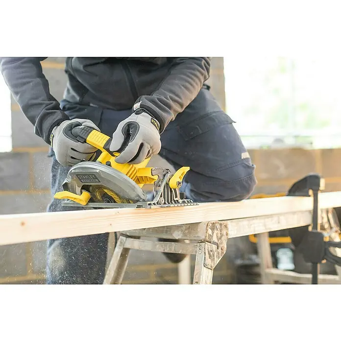 Stanley FatMax Sierra circular de mano FME301K-Q - 1.650 W, Diámetro hoja de sierra: 190 mm, Profundidad de corte a 90 °: 65 mm - Primer plano de una sierra circular Stanley Fatmax cortando una pieza de madera, operada por una persona con guantes de trabajo.