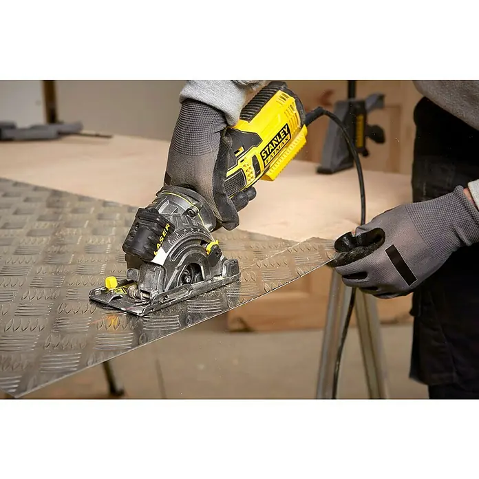Stanley FatMax Sierra circular de mano FME380K-QS - 650 W, Diámetro hoja de sierra: 89 mm, Profundidad de corte a 90 °: 28,5 mm - Primer plano de una sierra circular Stanley Fatmax cortando metal, centrándose en la precisión y la calidad de la herramienta.