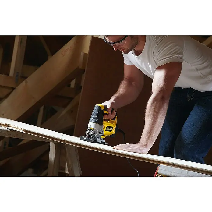 Stanley FatMax Elektro-Stichsäge FME340K-QS - 0 /min - 3.200 /min, 85 mm - Mann schneidet ein Brett mit einer Stichsäge von Stanley Fatmax, Schutzbrille tragend.