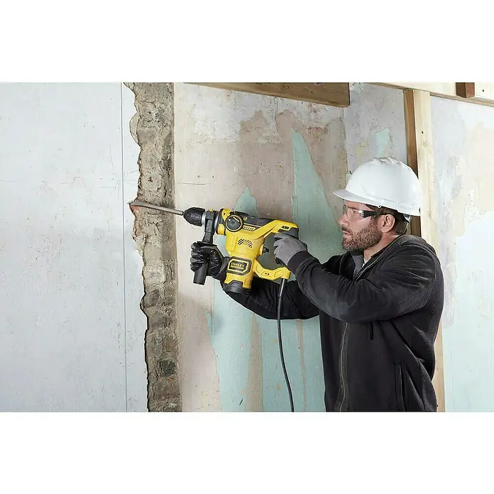 Stanley FatMax Martillo combinado FME1250K-QS - 1.250 W, 3,5 J, Alojamiento SDS-Plus - Un trabajador de la construcción utilizando el martillo perforador amarillo Stanley Fatmax en el trabajo.