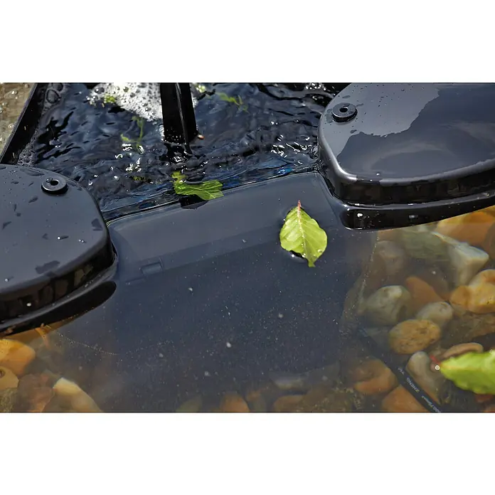 Oase Skimmer SwimSkim 25 - Leistungsaufnahme: 40 W, Fördermenge pro Std.: 2.500 l - Nahaufnahme eines Aquariums mit einem schwarzen Filter, Steinen und einigen Blättern im Wasser.
