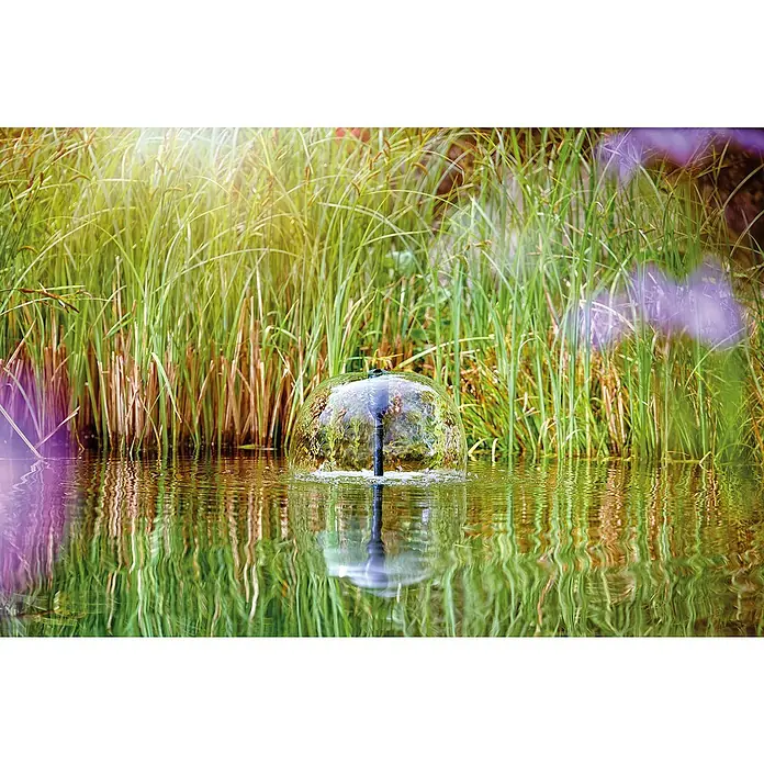 Oase Wasserspielpumpe Aquarius Set 2000 E - 18 W, Fördermenge pro Std.: 2.100 l - Dekorative Wasserspielfontäne im Gartenteich, umgeben von üppigem Grün, sorgt für eine beruhigende Atmosphäre und ist ein Blickfang.