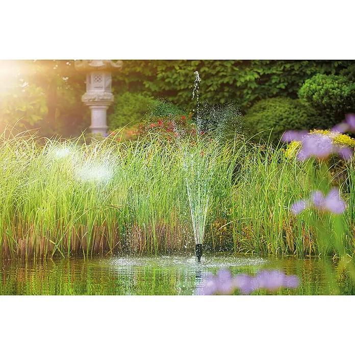 Oase Wasserspielpumpe Aquarius Set 2000 E - 18 W, Fördermenge pro Std.: 2.100 l - Gartenteich mit Springbrunnen und üppiger Vegetation, die eine ruhige und natürliche Atmosphäre schafft.