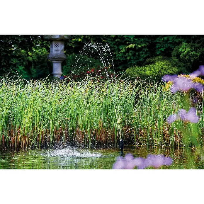 Oase Wasserspielpumpe Aquarius Set 2000 E - 18 W, Fördermenge pro Std.: 2.100 l - Der Springbrunnen mit der Fontäne ist von üppigem Grün umgeben und bietet einen ruhigen Anblick im Garten.